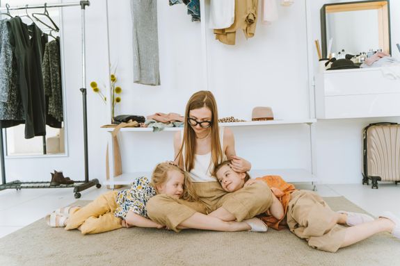 Mother with Little Daughters Sitting on Carpet Together