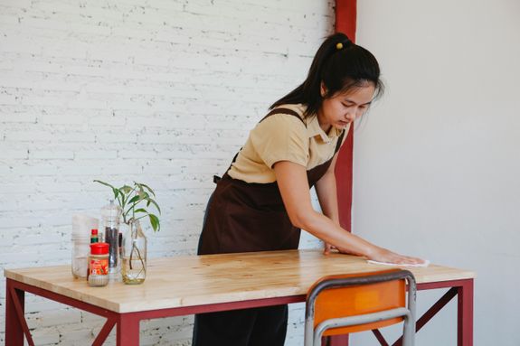 Woman Wiping The Table With Cloth