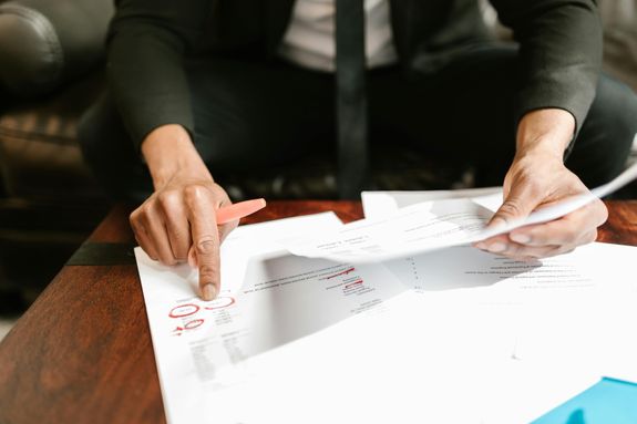 A businessman analyzing financial documents with important data and figures on a desk, ideal for business analytics and accounting themes.