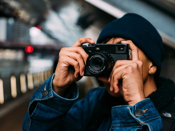 A person capturing a moment with a camera in an urban setting.