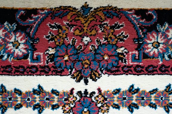 Close-up of a colorful traditional floral carpet with intricate patterns.