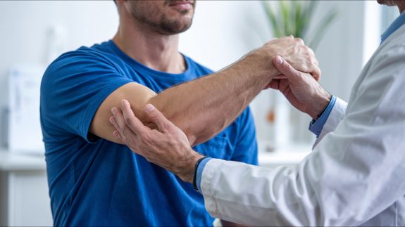 Physiotherapist Helping a Patient Exercise His Back