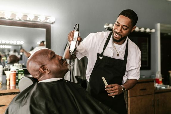 A Barber Trimming a Man's Beard