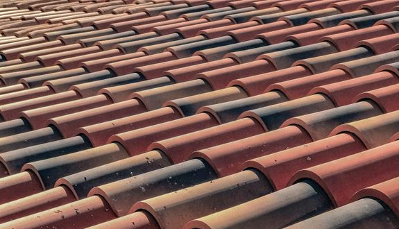 A detailed view of overlapping terracotta roof tiles creating a pattern, capturing a classic architectural style.