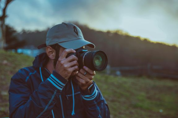 Man Holding Black Dslr Camera