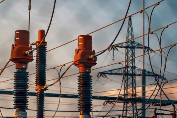 Detailed view of power transformers and lines against a sunset sky in Austria.