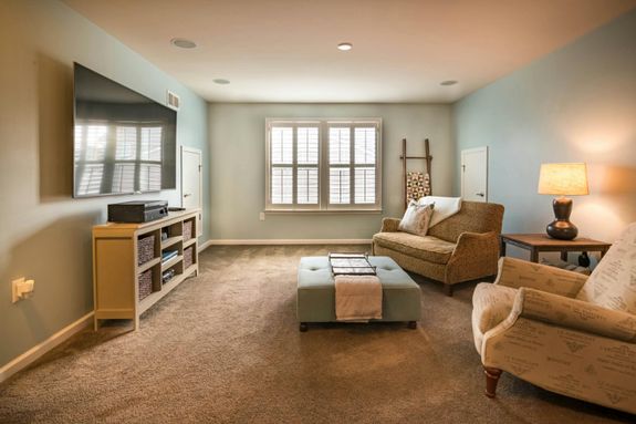 Modern living room featuring a cozy and stylish interior with sofa, armchair, and large TV.