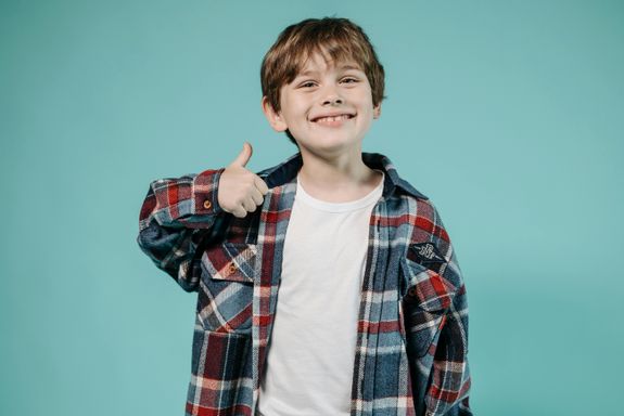 Boy in Red and Black Plaid Long Sleeve Shirt Doing a Thumbs Up