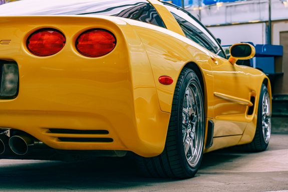 Close-up of a yellow Chevrolet Corvette parked outdoors, showcasing its sleek and modern design.