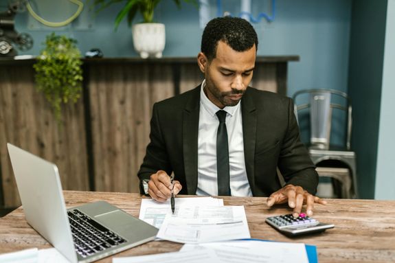Focused businessman works with calculator and documents