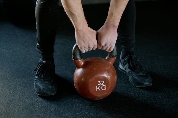 Person Holding Red Kettlebell