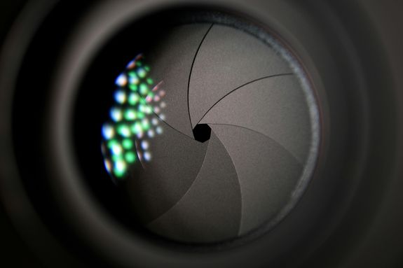 Detailed image of a camera lens aperture showing mechanical blades.