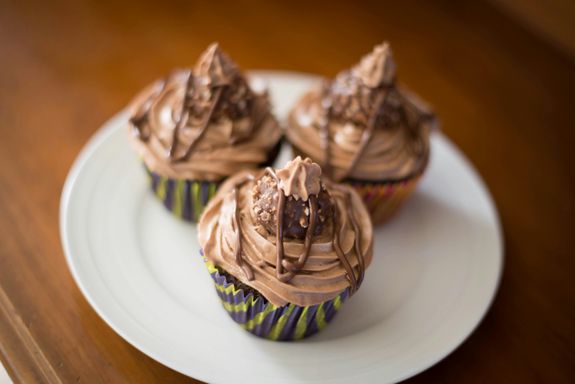 High angle selective focus of sweet chocolate cake decorated with cream served on white plate