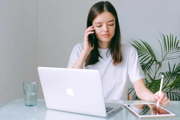 Woman in White Crew Neck T-shirt Using Silver Macbook