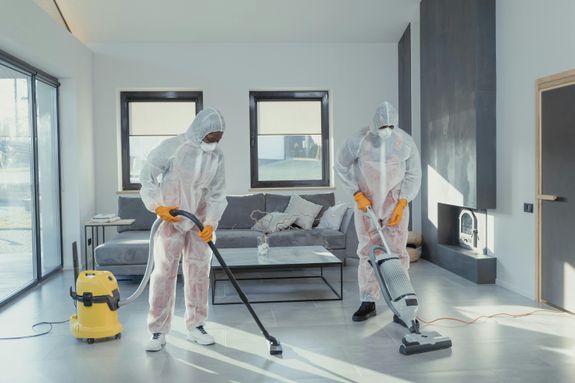 Cleaners in PPE Vacuuming a Tiled Floor