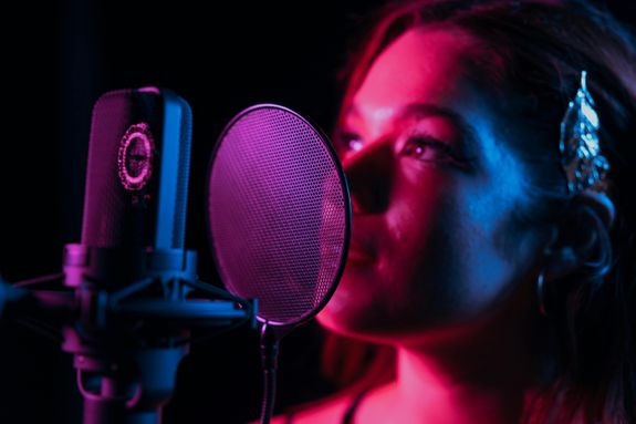 A Woman Singing in Front of the Pop Filter