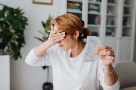 Unhappy Woman Holding Bill