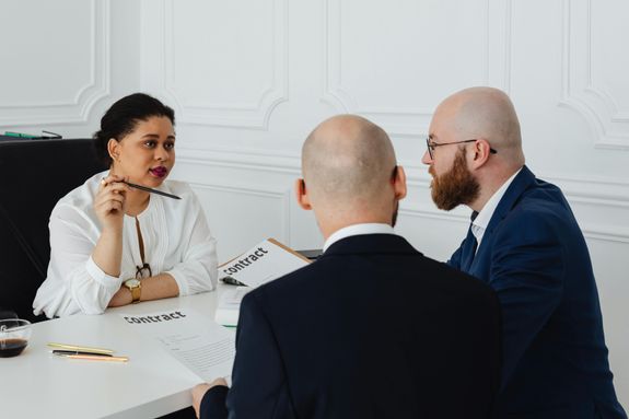 A Woman Talking to Men Holding Contracts