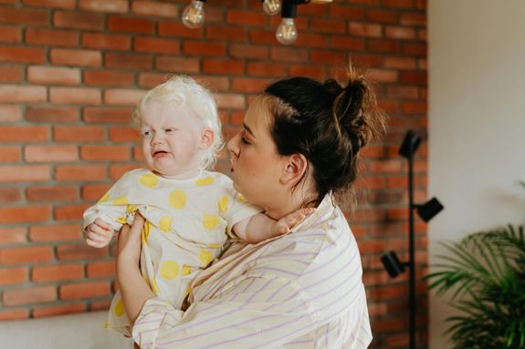 Woman in Striped Shirt Carrying Baby 