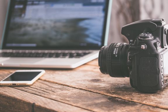 Black Dslr Camera on Beige Wooden Surface