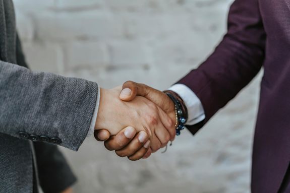 Professional handshake symbolizing cooperation and partnership in a business setting.