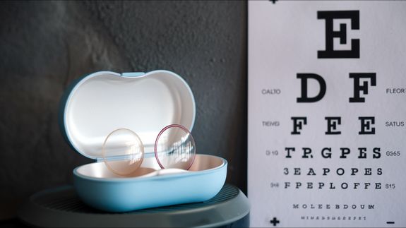 Crop unrecognizable female ophthalmologist showing eyeglasses
