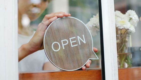open sign hanging on physical storefront