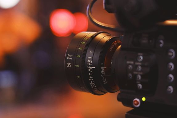 Detailed close-up of a camera lens with blurred bokeh background, capturing modern photography equipment.