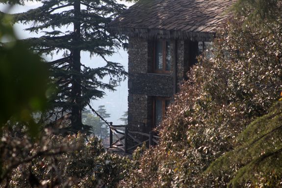 a stone building surrounded by trees and bushes