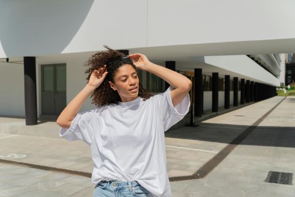 A Woman in White T-Shirt Holding her Sunglasses