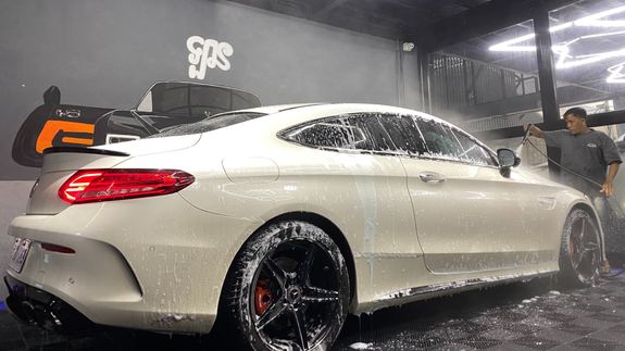 Photo of a Woman Washing a Black Car