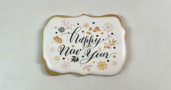 Biscuit gastronomique peint à la main avec les mots "Happy New Year" écrits dessus