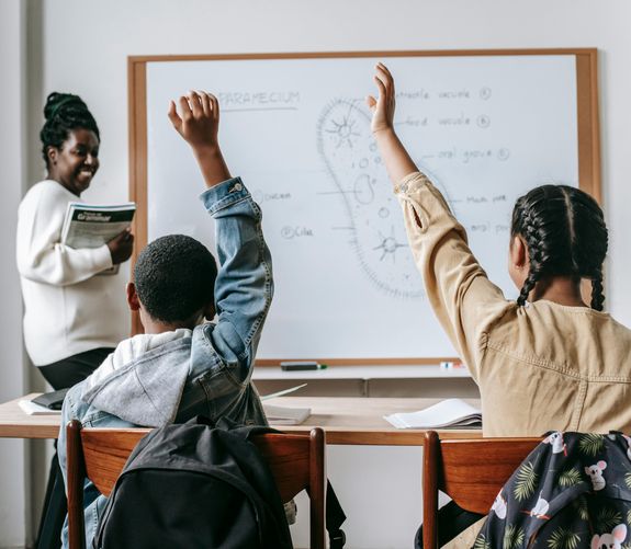 Woman in White Long Sleeve Shirt Sitting Beside Woman in Red Shirt