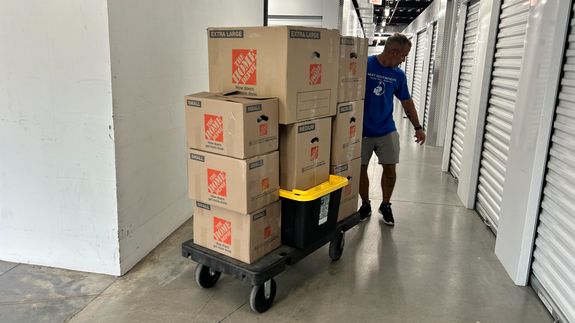 Man Carrying Boxes Beside a Van