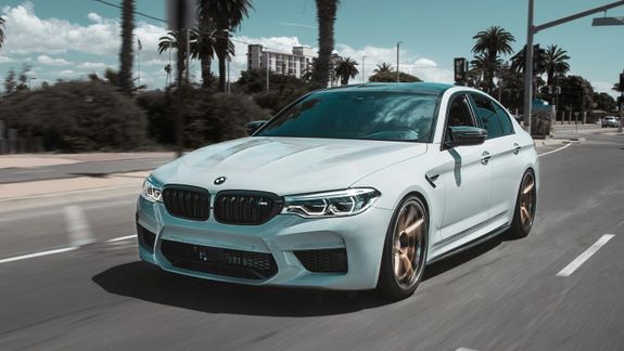 Closeup daytime running lights switched on of modern new polished luxury gray automobile